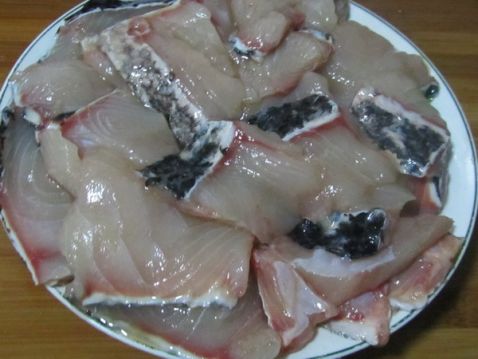 杀好的生鱼,将鱼骨去掉 去掉鱼骨的生鱼肉切成片,用盐,料酒腌制15分钟